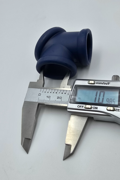 Caliper measuring opening of blue silicone 3-way contoured ball stretcher