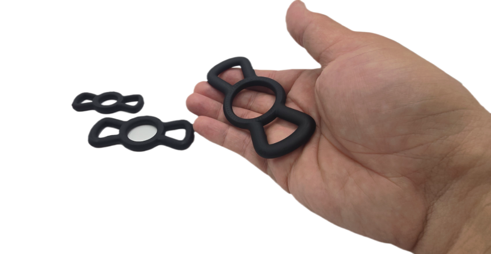 Hand holding large Winged Silicone Restriction Ring with medium and small sizes displayed